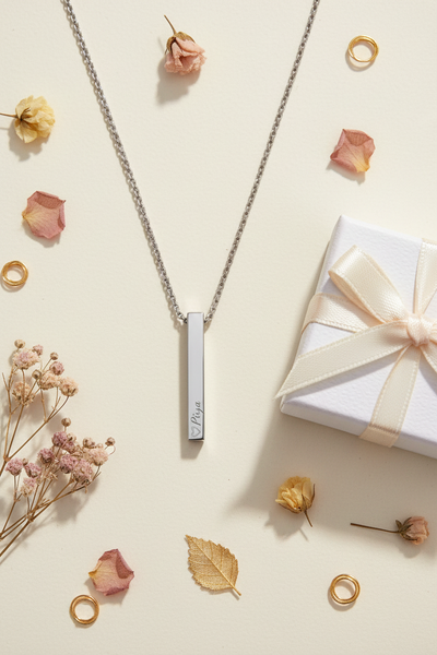 Custom engraved bar pendant flat lay - Priya with dried flowers and gift box